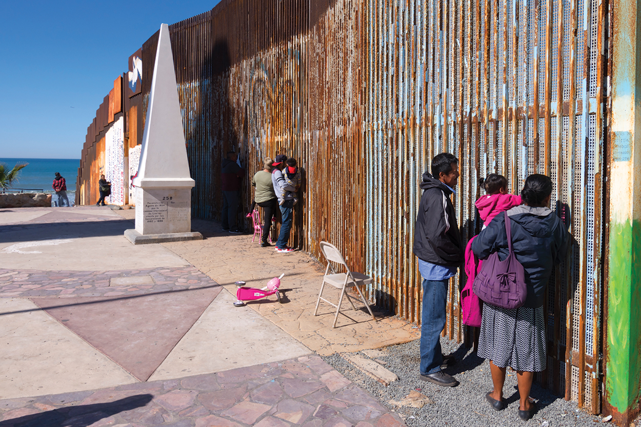 Immigrant family standing at fence