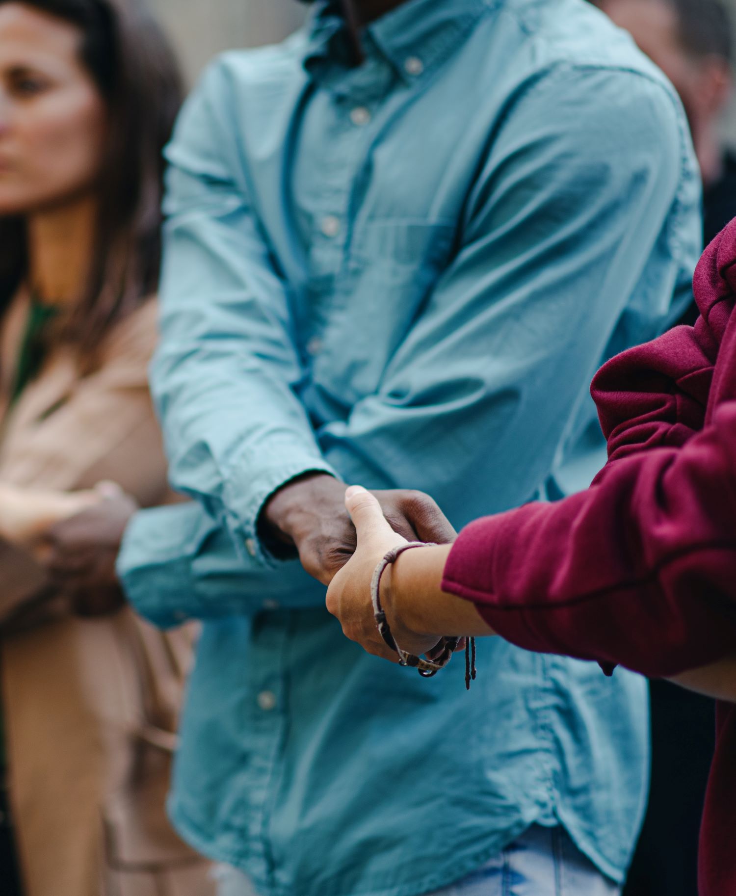 A closeup showing a circle of people holding hands