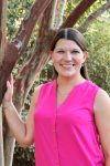 headshot of the author, Stephanie Opiela, standing beside a tree